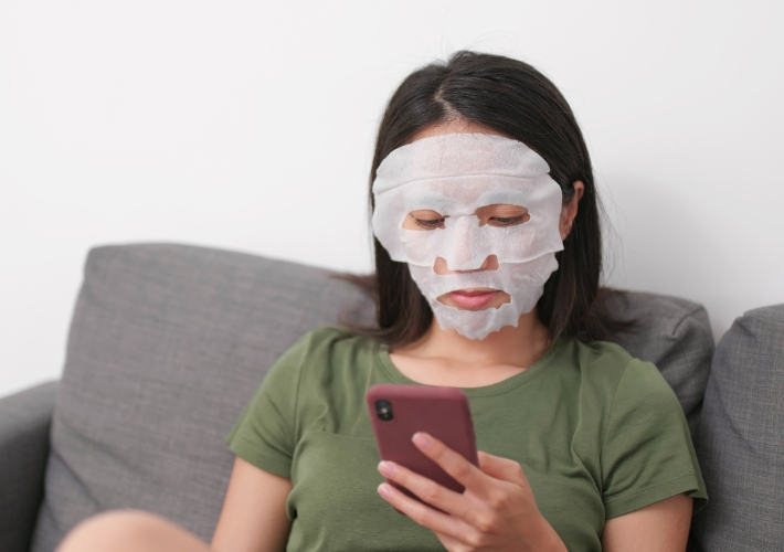 Sitting Woman with Sheet Mask on Face