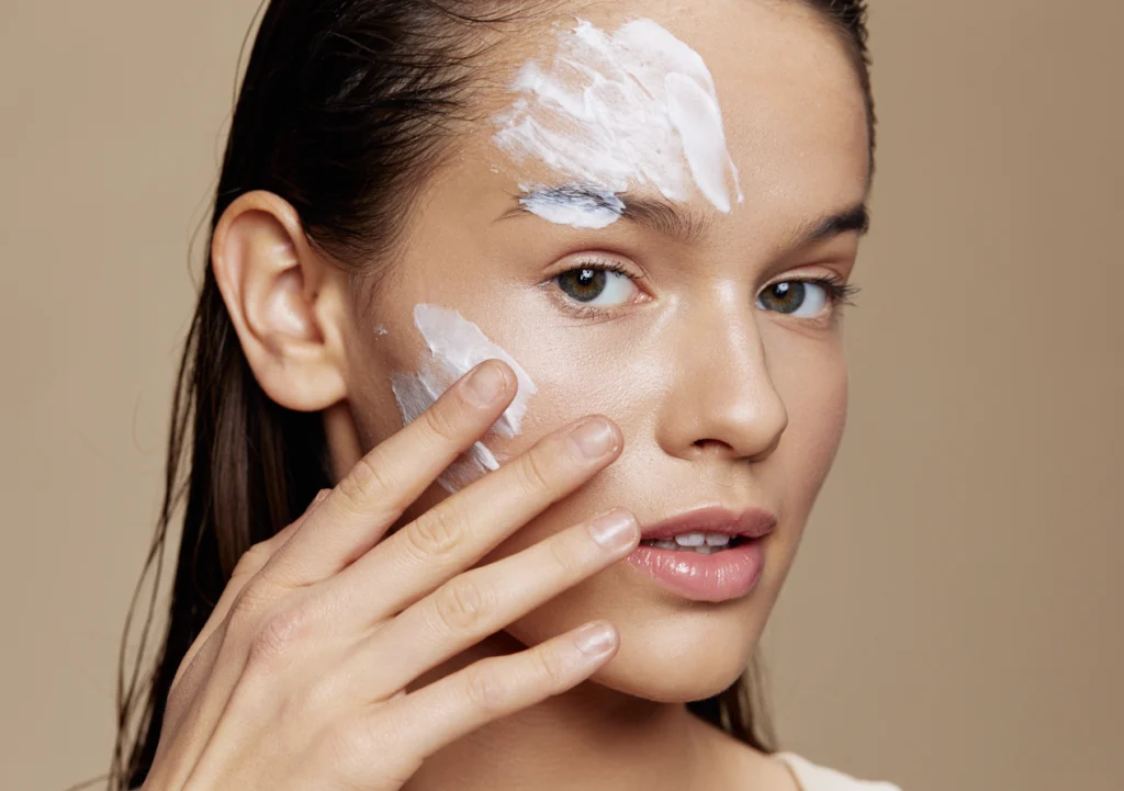 Young Girl Rubs Face White Cream on Her Face