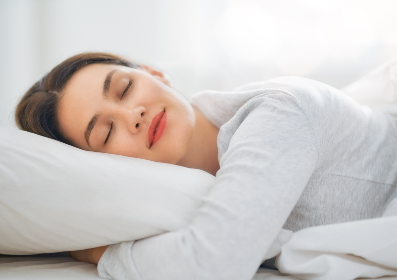 A Woman Smiling while Sleeping with Her Head on the Pillow