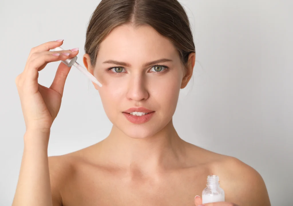 Woman is Applying Face Serum Using a Dropper