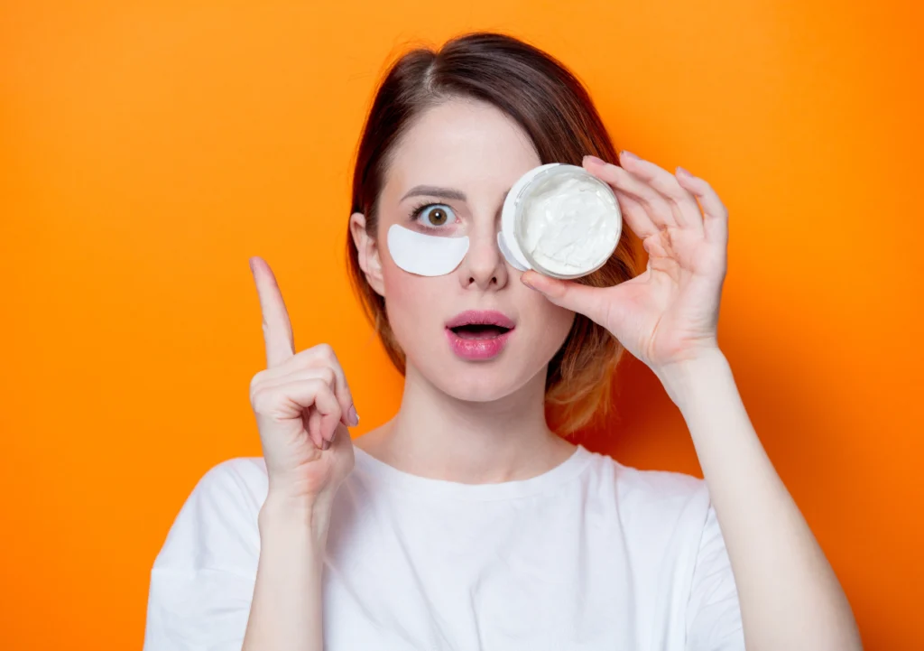A Young Girl Holding a Face Cream in Front of Her Eye