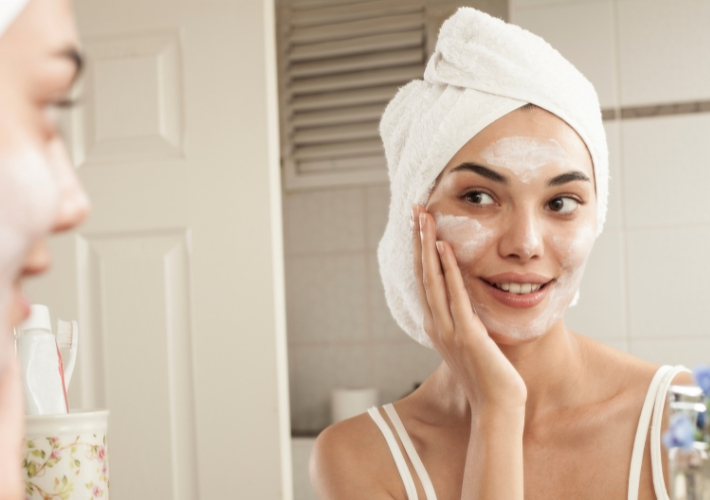 Smiling Young Woman Rubbing Some Cream on Face