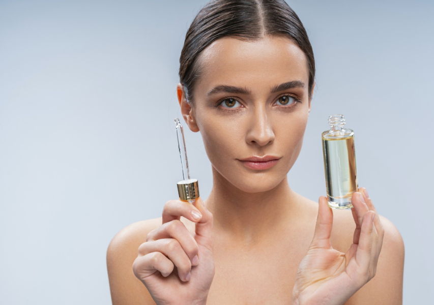 Young Woman Holding Face Serum while Looking at Camera