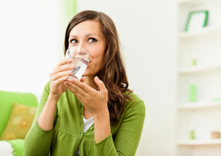 Woman in Green Clothes Drinking Water