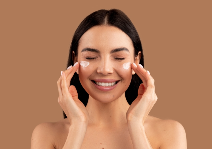 Smiling Woman Adding Face Cream on Cheeks