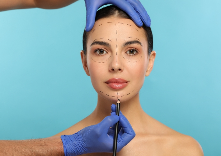 Doctor is Drawing Dotted Lines on Young Woman's Face