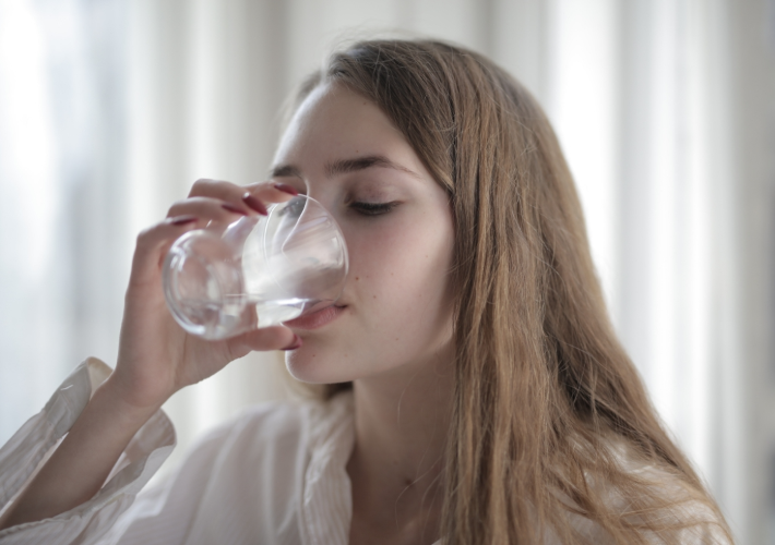 Beautiful Young Woman is Drinking Water