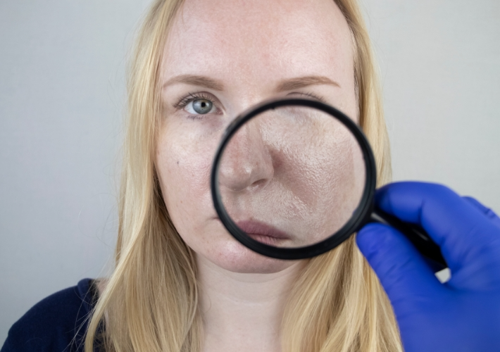 A Magnifier is Holding in Front of Woman's Face